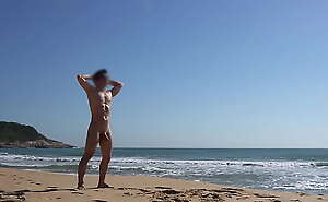 Na praia nudista tomando sol